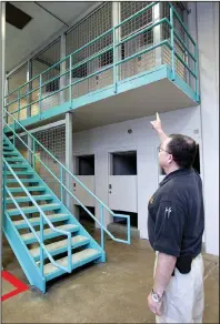  ?? Arkansas Democrat-Gazette/JEFF MITCHELL ?? Pulaski County jail supervisor
Lt. Rodney Sheperd shows where an inmate fell over the second-floor railing, prompting the installati­on of fencing to prevent another accident.