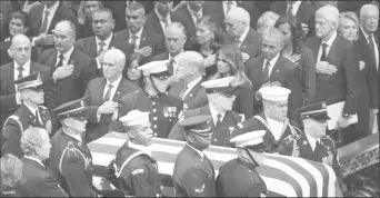  ??  ?? The flag-draped casket of former President George H.W. Bush is carried by a military honor guard past former President George W. Bush and wife Laura Bush, President Donald Trump, first lady Melania Trump, former President Barack Obama, Michelle Obama, former President Bill Clinton, former Secretary of State Hillary Clinton and former President Jimmy Carter during a State Funeral at the National Cathedral on Dec. 5, 2018, in Washington.CLINTON WIPES AWAY TEARS