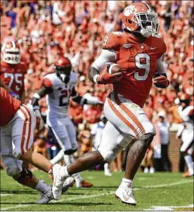  ?? MIKE COMER / GETTY IMAGES ?? Clemson running back Travis Etienne, who had a career-high 203 yards rushing, scores the go-ahead TD against Syracuse late in the fourth quarter Saturday.