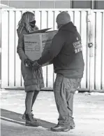  ?? PHOTOS BY RYAN GARZA/DETROIT FREE PRESS ?? Chatman picks up a box of food from Berkley Common owner Katie Kutscher at her restaurant. United Wholesale Mortgage is taking food to homeless shelters in the area.