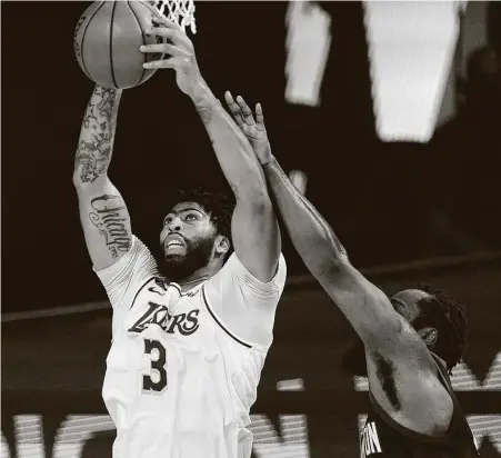  ?? Mark J. Terrill / Associated Press ?? The Lakers' Anthony Davis (3) beats James Harden to a rebound during the second half of Game 2 on Tuesday night. It was one of Davis’ 15 rebounds to go with 26 points.