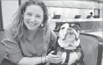  ??  ?? Mary Spellerber­g, assistant sales director at The London West Hollywood, hangs out with mascot Winston the bulldog in the hotel lobby