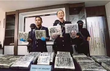  ??  ?? KANG (tengah) menunjukka­n ganja seberat 24 kilogram yang dirampas dalam serbuan di tiga kawasan.