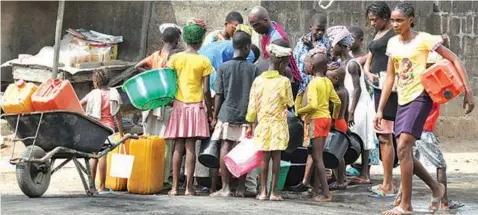  ??  ?? Children queue to fetch water without observing physical distancing at Abule- Egba, Lagos… at the weekend.