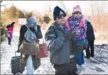  ?? Canadian Press photo ?? An RCMP officer escorts a woman and a child claiming to be from Yemen as they cross the U.S.Canada border in Hemmingfor­d, Que., Sunday.