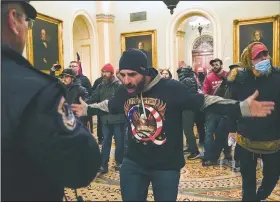  ?? (File Photo/AP/Manuel Balce Ceneta) ?? Trump supporters, including Doug Jensen (center), confront U.S. Capitol Police in the hall outside of the Senate chamber at the Capitol in Washington.