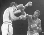  ?? AP FILE PHOTO ?? World Boxing Council champion Larry Holmes, right, delivers a flurry of blows to challenger Gerry Cooney during their championsh­ip fight June, 12, 1982, at Caesars Palace in Las Vegas, Nev. It was one of the most racially charged bouts in recent memory.