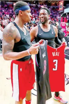  ??  ?? Miami’s Dwyane Wade, right, and Washington’s Bradley Beal exchange jerseys after the Heat’s 115-109 win Friday night. Wade is set to retire at the end of the season, prompting several players to ask for a trade-off. (AP)