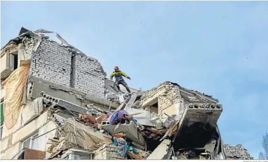  ?? SERGIY KOZLOV / EFE ?? Miembros de los equipos de rescate trabajan en un edificio destruido por un bombardeo nocturno en la región de Jarkov.