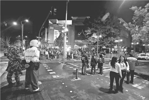  ??  ?? People and security personnel stand outside the Andino shopping center after an explosive device detonated in a restroom, in Bogota. — Reuters photo