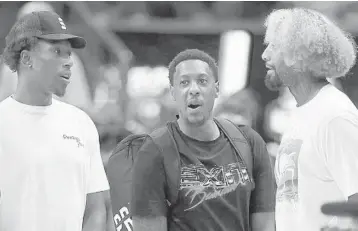  ?? MIKE EHRMANN/GETTY ?? Heat forward James Johnson (right) talks Saturday with former Heat players Josh Richardson (left) and Mario Chalmers.