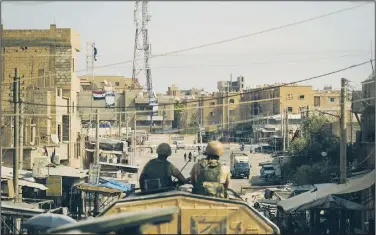  ?? AP ?? Soldiers look out on the city of Deir ez-Zor, Syria, on Friday. Syrian government forces have kept up their offensive on Deir el-Zour, capturing a new neighborho­od from the Islamic State and increasing their hold to over 60 percent of the city.