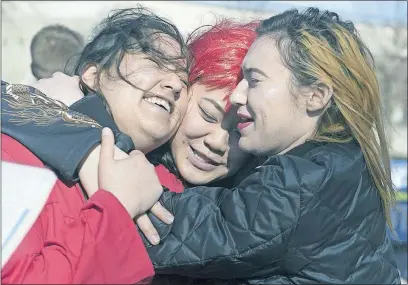  ?? [HALEY NELSON/PITTSBURGH POST-GAZETTE] ?? From left, Carnegie Mellon University art majors Maya Zane Kaisth, Clair Chin and Levitt Summer embrace on the Pittsburgh campus during an Internatio­nal Women’s Day rally.