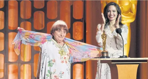  ??  ?? French director Agnes Varda, left, celebrates onstage with her honorary Oscar as presenter Angelina Jolie looks on at the 2017 Governors Awards in Los Angeles.