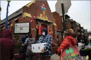  ?? (AP/Jessie Wardarski) ?? People receive free food from the United Sherpa Associatio­n’s weekly food pantry in the Queens borough of New York. The pantry began in April with a focus on the Nepalese community, internatio­nal students and families living in the country without permission.