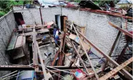  ??  ?? Victims of a windstorm in Kampung Perlis, Balik Pulau, cleaning up their home yesterday.