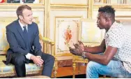  ?? THIBAULT CAMUS/AFP/GETTY IMAGES ?? French President Emmanuel Macron speaks with Mamoudou Gassama, who climbed a Paris apartment building on Saturday night to rescue a 4-year-old child.