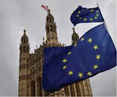  ??  ?? The Union flag flies atop the Houses of Parliament as EU flags held by demonstrat­ors flutter in central London. — AFP photo