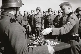  ??  ?? ■ Iron Crosses were awarded in their thousands during the Second World War. Some of the roughly 3.7 million Iron Cross 2nd Class medals awarded between 1939 and 1945 are being issued here.