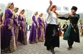  ??  ?? Chechen people perform a traditiona­l dance in the village of Kezenoyam.