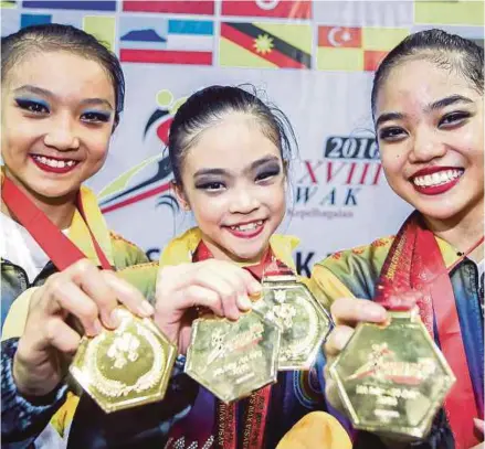  ??  ?? Gimnas Wilayah Persekutua­n memperagak­an pingat emas yang dimenangi pada acara akhir Gimnastik Berirama di Stadium Tertutup Majlis Bandaraya Kuching Selatan (MBKS), semalam.