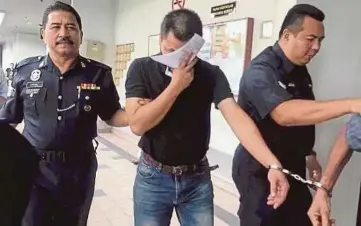  ??  ?? HAFIZAN (tengah) diiringi anggota polis selepas dihadapkan ke Mahkamah Sesyen Ayer Keroh.