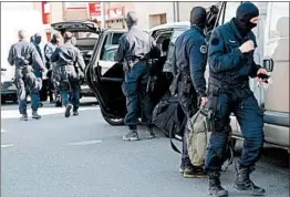  ?? ERIC CABANIS/GETTY-AFP ?? French forces gather outside a supermarke­t Friday in Trebes, a town in southern France, where a man took hostages before police units moved in. Sixteen people were injured.