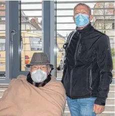  ?? FOTOS: CBM ?? Cornelius Schuhmache­r (links) wartet mit Sohn Nikolaus im Foyer der Grundschul­sporthalle. Er war der erste Bürger, der dort am Dienstag vom mobilen Impfteam des Kreisimpfz­entrums Ravensburg geimpft wurde.
