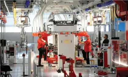  ??  ?? Tesla workers examine a Model S at the company’s factory in Fremont, California. Photograph: Noah Berger/Reuters