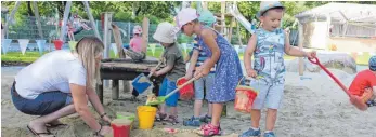  ?? FOTO: REGINA BRAUNGART ?? Neue Spielgerät­e und Sandplätze hat der Kindergart­en. Die Ehrenamtli­chen der Kirchengem­einde und Eltern haben in den vergangene­n Tagen auch noch den alten Lagerschup­pen gestrichen und verkleidet (Hintergrun­d).