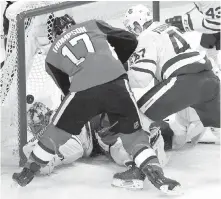  ??  ?? Ottawa centre Nate Thompson chips the puck past Toronto goalie Frederik Andersen as centre Leo Komarov defends.