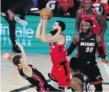  ??  ?? Raptors guard Fred VanVleet shoots as Heat guard Goran Dragic tries to draw the foul during the second half in Lake Buena Vista, Florida on Monday.