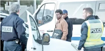  ??  ?? French policmen detain migrants on the A63 road at the border crossing of Biriatou, southweste­rn France. — AFP photo