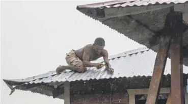  ??  ?? 0 A man secures the roof of his house in Bilwi, Puerto Cabezas, Nicaragua