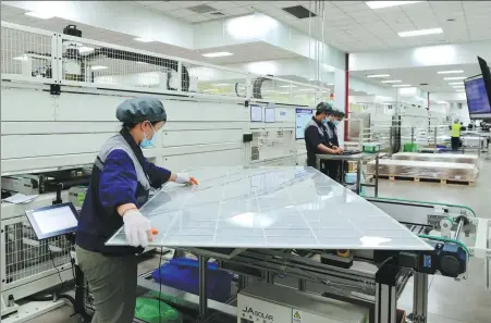  ?? SHI BUFA / FOR CHINA DAILY ?? Workers assemble photovolta­ic panels at a smart workshop in Yiwu, Zhejiang province, in June 2021.