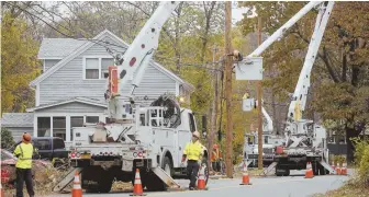  ?? STAFF PHOTO BY NICOLAUS CZARNECKI ?? WORKING ON IT: National Grid subcontrac­tors work on repairing power lines yesterday along Lake Street in Haverhill.