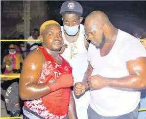  ?? ANTHONY MINOTT PHOTOS ?? Main organiser, Young Wild Apache (centre), of the charity boxing spectacle, takes a photo with heavyweigh­t boxers Dwayne Smith (right) and Ryan Gordon during the second bout in a charity boxing clash dubbed ‘Jump Out, Thump Out’ in Cockburn Gardens recently.
Left: Oraldo ‘Jubba’ Stephenson (left) of Mandella Terrace and Miracle Rhakeam from Cockburn Gardens battle in the ring during a charity boxing clash dubbed ‘Jump Out, Thump Out, in Cockburn Gardens recently. Miracle won the bout.
Below: This lady introduces the next round during a charity boxing clash dubbed ‘Jump Out, Thump Out’ in Cockburn Gardens recently.