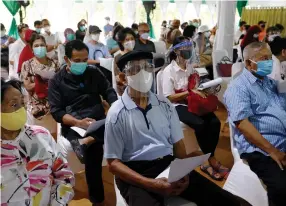  ?? (Ajeng Dinar Ulfiana/Reuters) ?? PEOPLE WEARING protective masks and face shields wait for their doses of China’s Sinovac Biotech vaccine for the coronaviru­s disease at Indonesia’s health ministry in Jakarta, last week.