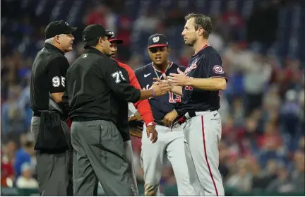  ?? THE ASSOCIATED PRESS ?? Washington Nationals’ Max Scherzer, right, is checked by the umpires for foreign substances during Tuesday night’s 3-2victory over the Phillies.