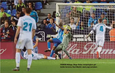  ??  ?? PEMAIN Malaga, Diego Rolan menjaringk­an gol ketika bertemu Real Madrid, awal pagi semalam.