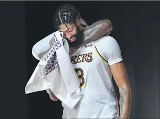  ?? WALLY SKALIJ Los Angeles Times ?? ANTHONY DAVIS I S HUGGED from behind in the f inal moments of Game 6 on Sunday. Davis could opt out of his contract next season after winning his f irst NBA championsh­ip.