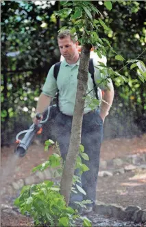  ?? HYOSUB SHIN, HSHIN@AJC.COM ?? A mosquito specialist for Northwest Exterminat­ing sprays for mosquitoes at a Marietta home in 2012. Warming temperatur­es and global travel have contribute­d to a rise in vector-borne illnesses.