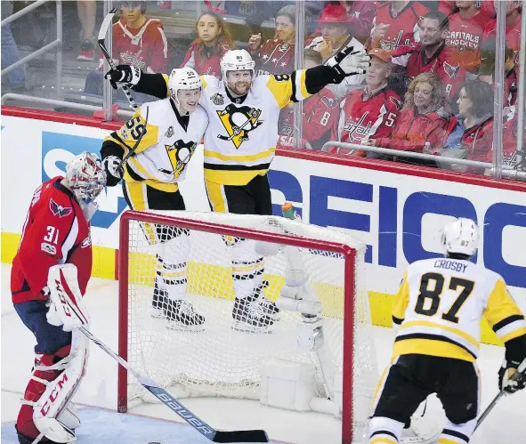  ?? — AP PHOTO ?? Phil Kessel, directly behind the net, celebrates his goal against the Capitals’ Philipp Grubauer with Penguins teammates Jake Guentzel and Sidney Crosby during the third period of Game 2 of their second-round playoff series on Saturday night in...