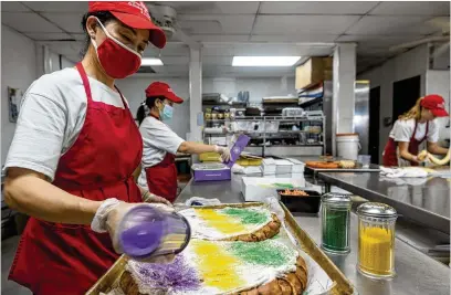  ?? L. KASIMU HARRIS/THE NEW YORK TIMES ?? King cakes are decorated at Dong Phuong Bakery in New Orleans East. The colorful cake is more than a dessert — it’s the flavor of New Orleans — and the city’s diverse bakers are adapting the Carnival specialty to their own tastes.