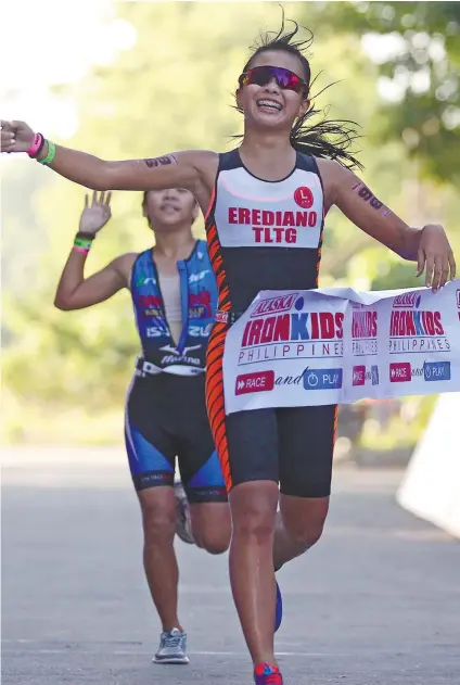  ?? CONTRIBUTE­D FOTO ?? NO. 1. Moira Erediano celebrates after crossing the finish line first in the Alaska Ironkids Girls 13-14 division.