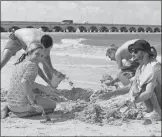  ??  ?? Arriba, una familia juega en la playa. A la izquierda, un grupo de amigos en el malecón de Progreso