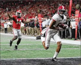  ?? CURTIS COMPTON / CCOMPTON@AJC.COM ?? Alabama wide receiver Devonta Smith catches the game-winning touchdown pass past Georgia defensive back Malkom Parrish for a 26-23 victory during overtime in the College Football Playoff National Championsh­ip on Jan. 8 in Atlanta.