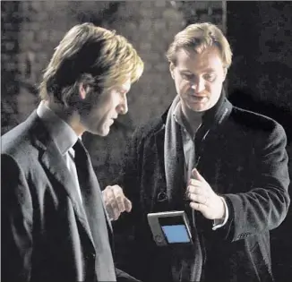  ?? Stephen Vaughan Warner Bros. Pictures / DC Comics ?? DIRECTOR Christophe­r Nolan, right, with actor Aaron Eckhart. “The Dark Knight’s” inf luence on superhero movies — and Hollywood as a whole — continues undiminish­ed a decade later.