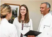  ?? Courtesy of MD Anderson ?? APRN Fellows Brie Urschel and Nilesh Kalariya interact with a patient during their clinical rotations.