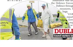  ??  ?? Council workers lay out sandbags